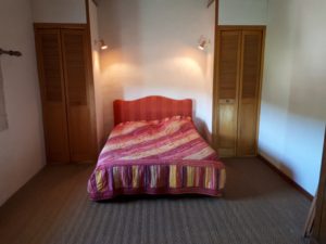 Le Tineiral à Néffies, apartment Les Romarins. The large bedroom includes a double bed and has views onto the garden and surrounding vineyards.